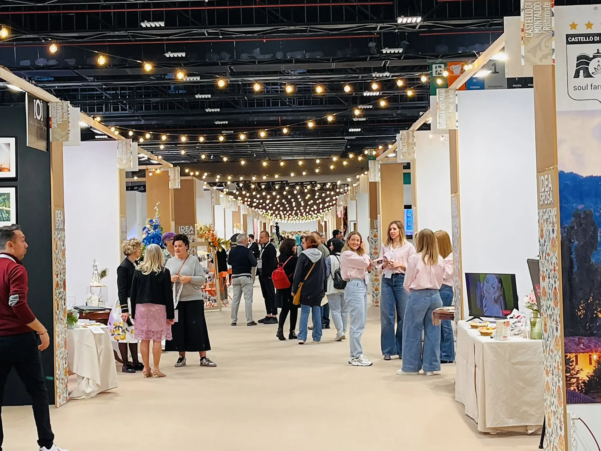 La corsia centrale di Idea Sposa Torino gremita di visitatori sotto le luci a festa
