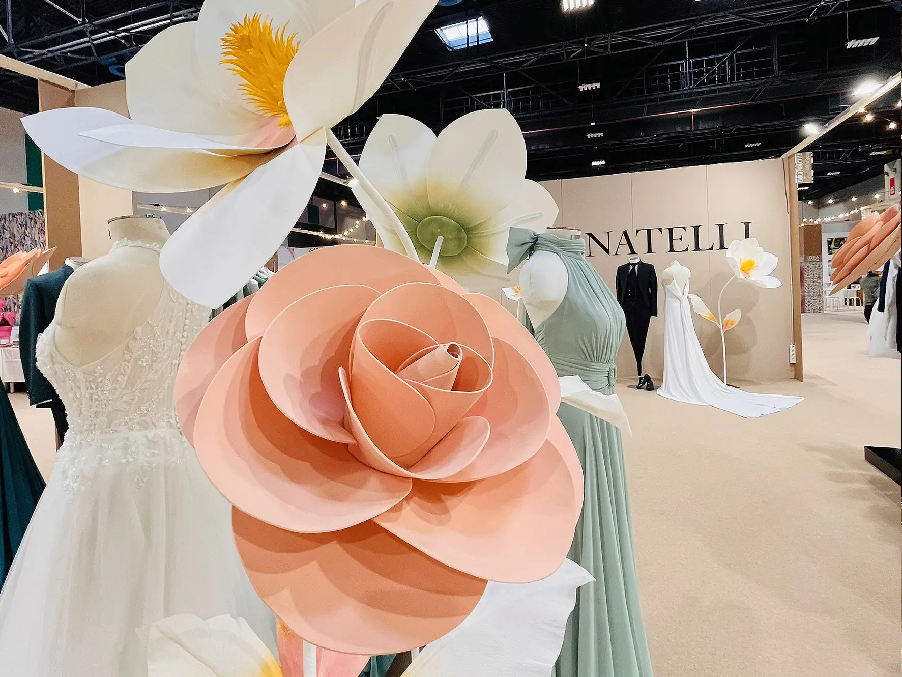 Fiori di carta giganti davanti agli abiti da sposa e da cerimonia a Idea Sposa Torino